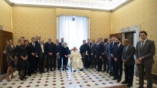 Pope Francis stands with a group of leaders in a room at the Vatican.