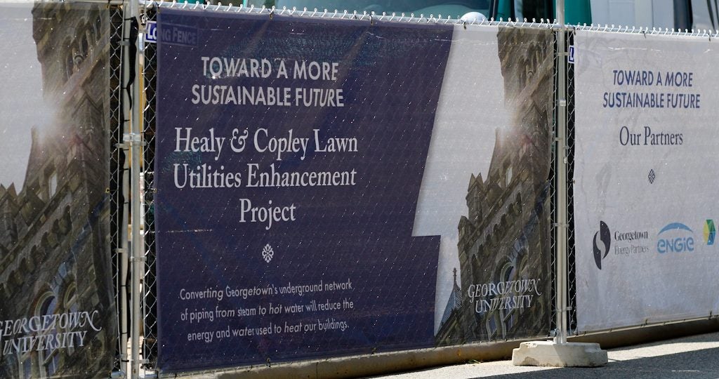 Signs on a fence that say "Healy & Copley Lawn Utilities Enhancement Project"