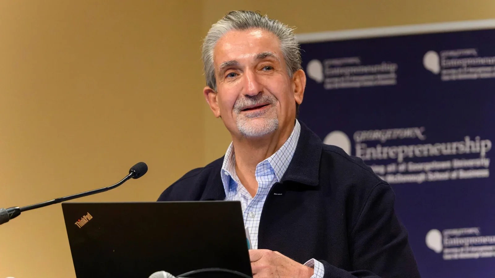 Ted Leonsis speaks behind a podium at Georgetown.