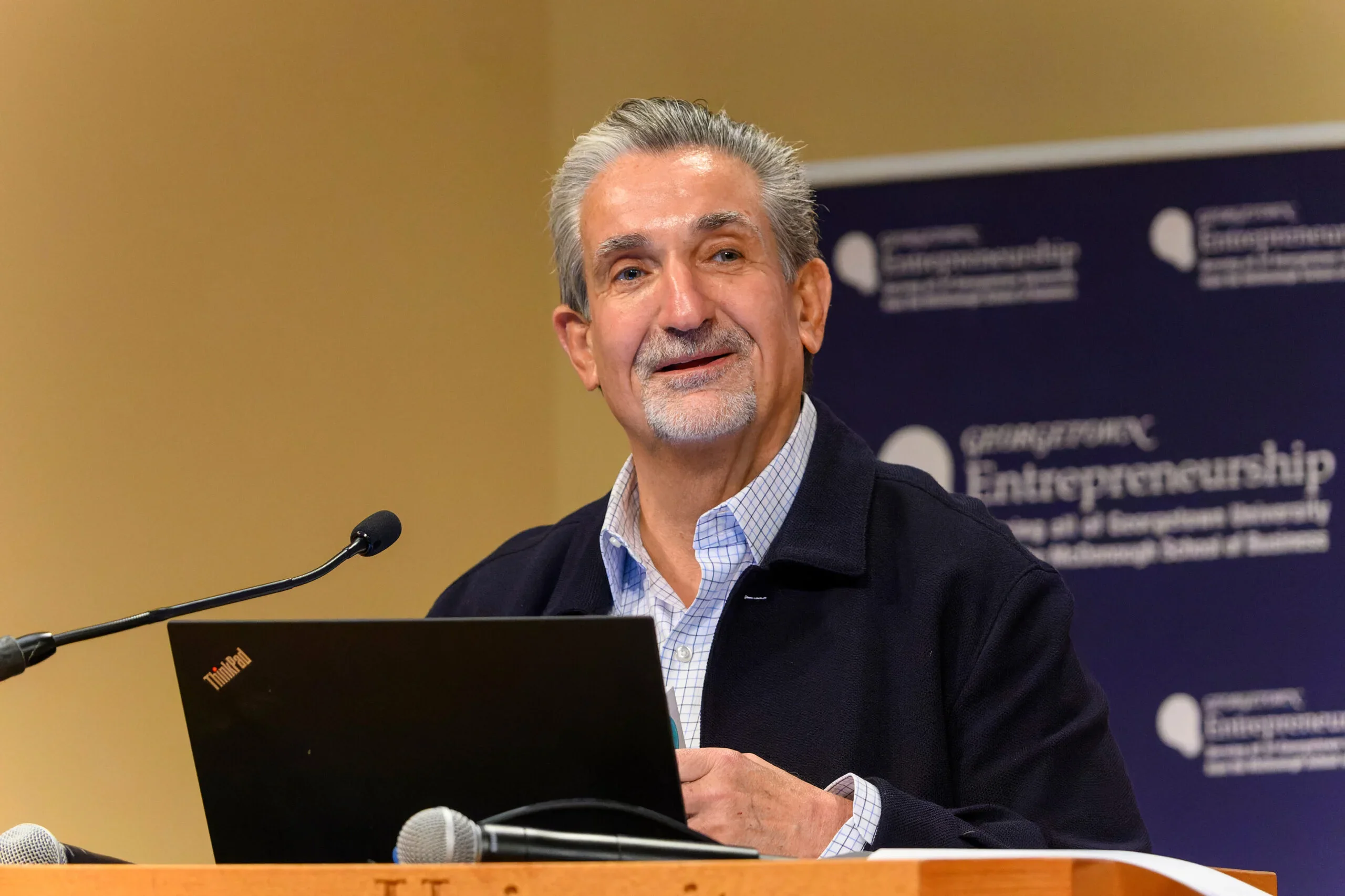 Ted Leonsis speaks behind a podium at Georgetown.