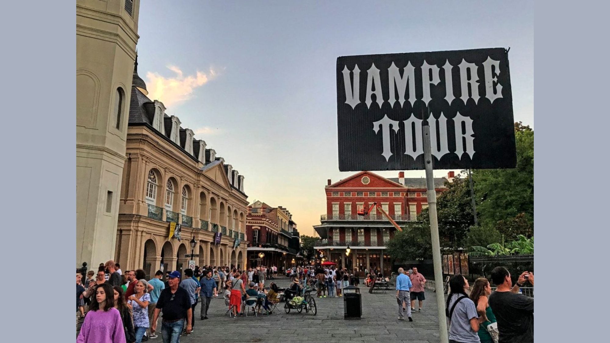 city street with sign in forefront that reads &quot;Vampire Tour&quot;