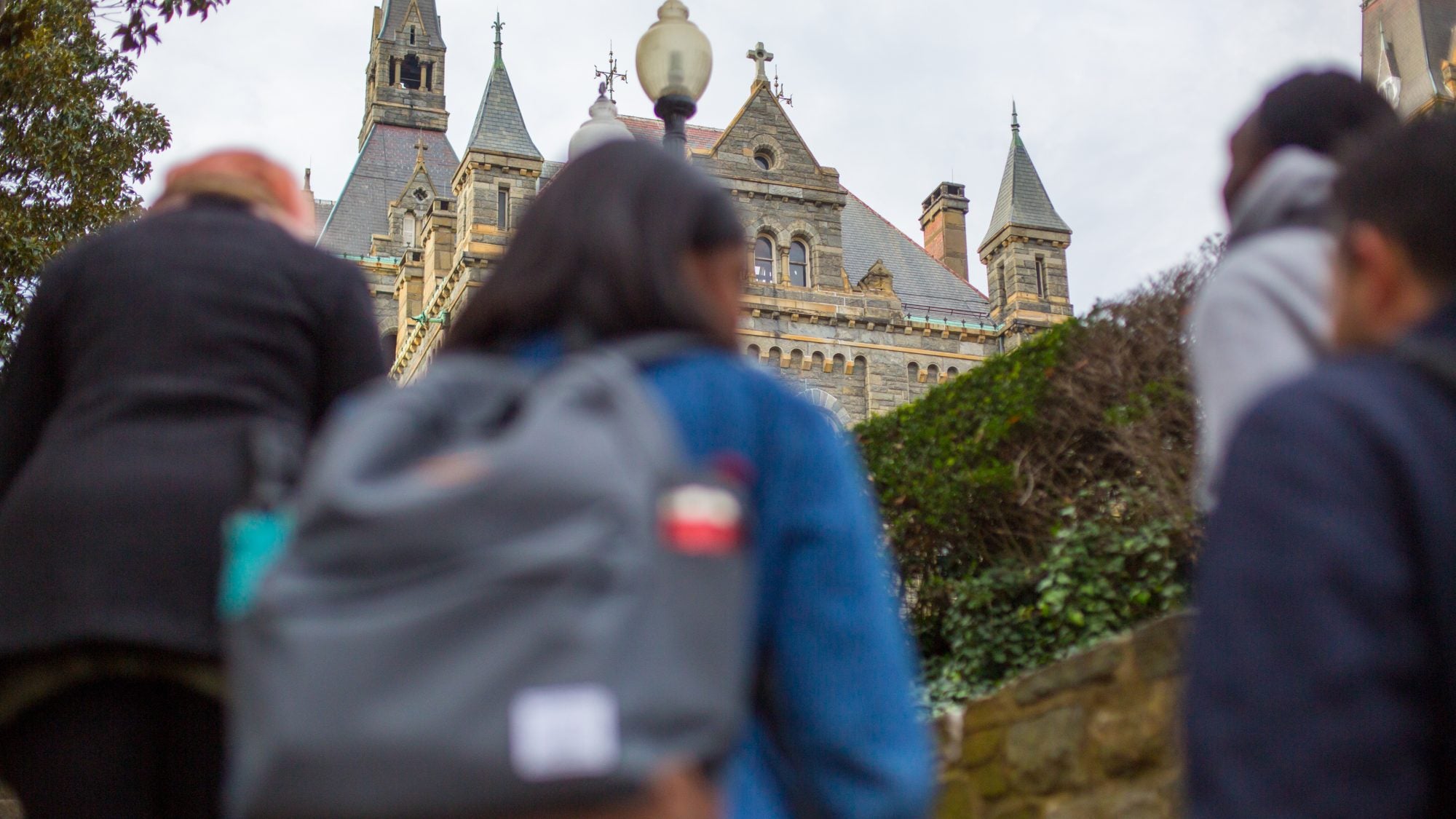 Students with backpacks walk up stairs to Georgetown.