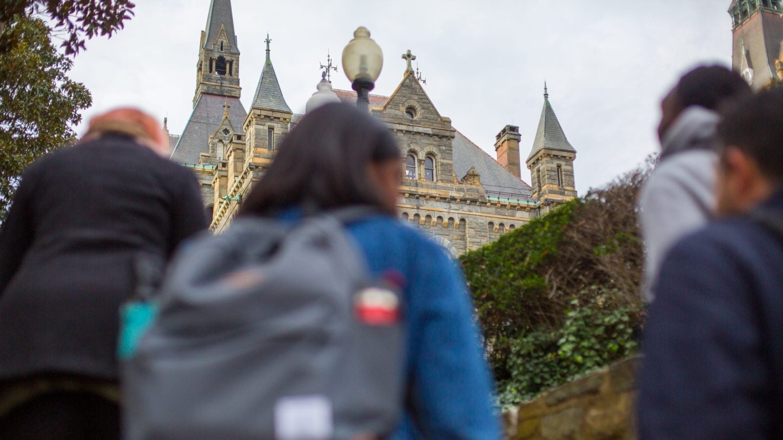 Students with backpacks walk up stairs to Georgetown.