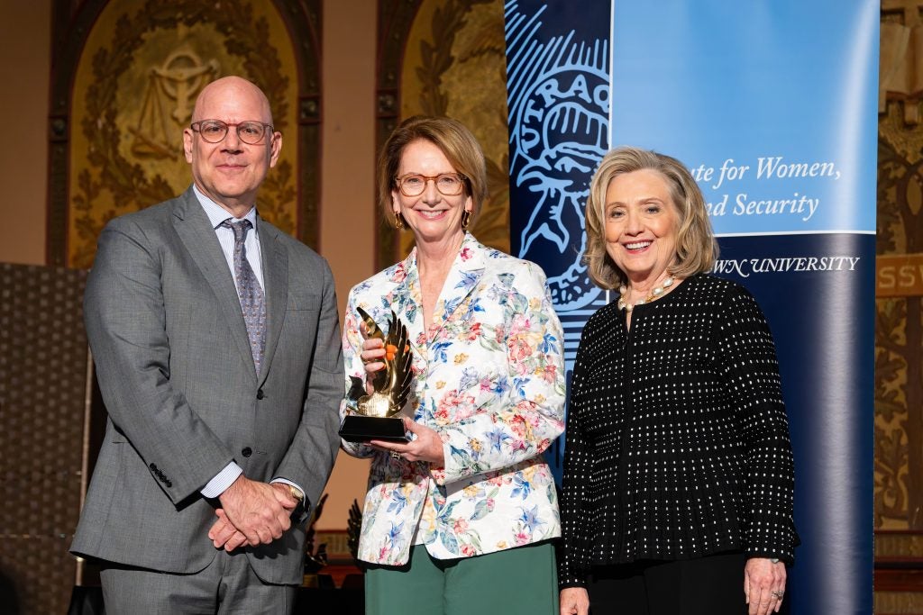 Julia Gillard holds an award alongside Hillary Clinton and Dean Joel Hellman at Georgetown.