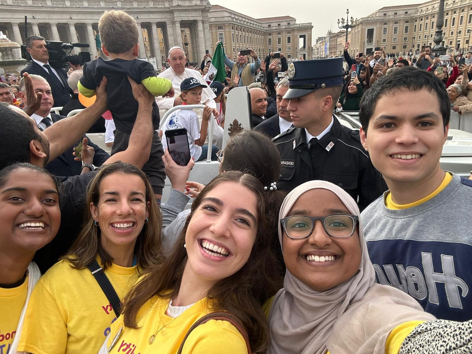 Alejandra with Georgetown students in a crowd with Pope Francis in the background