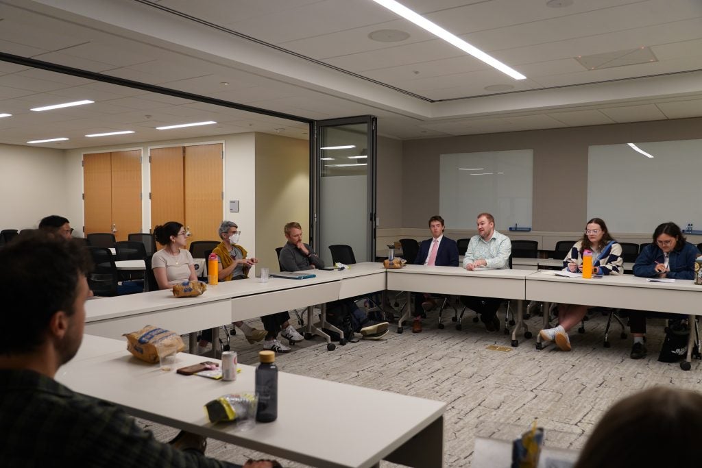 Merivaki speaking in a room with people sitting at a U-shaped conference table