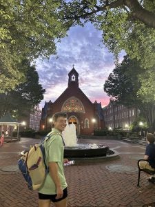 Luke in a green shirt on Dahlgren Quad in the evening