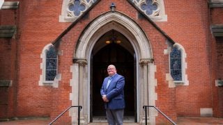 Wickman standing in front of Dahlgren Chapel