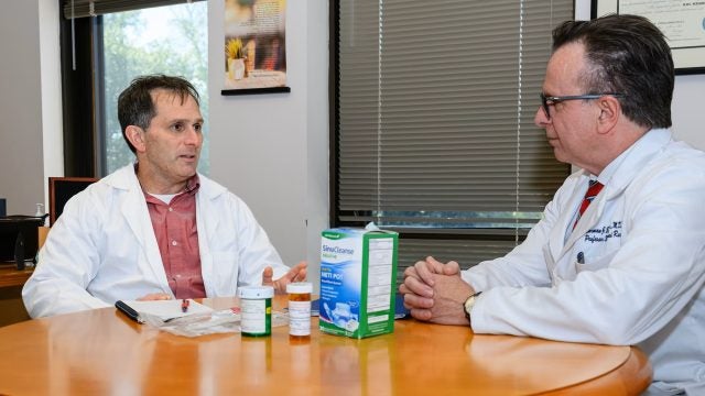 Two doctors in white coats talking at a table