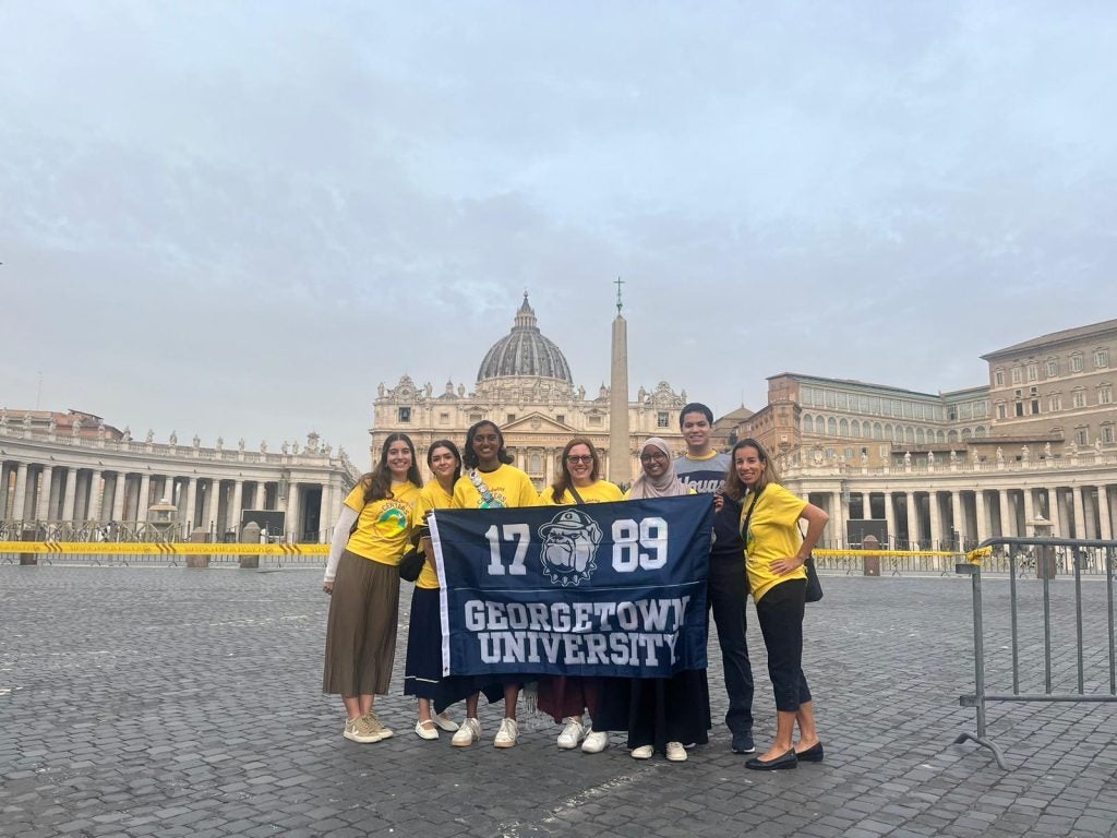 Georgetown students holding a GU Flag at the Vatican