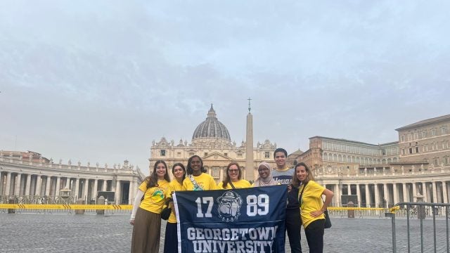 Georgetown students holding a GU Flag at the Vatican