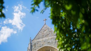 A view of a cross on a stone building on a sunny day at Georgetown.