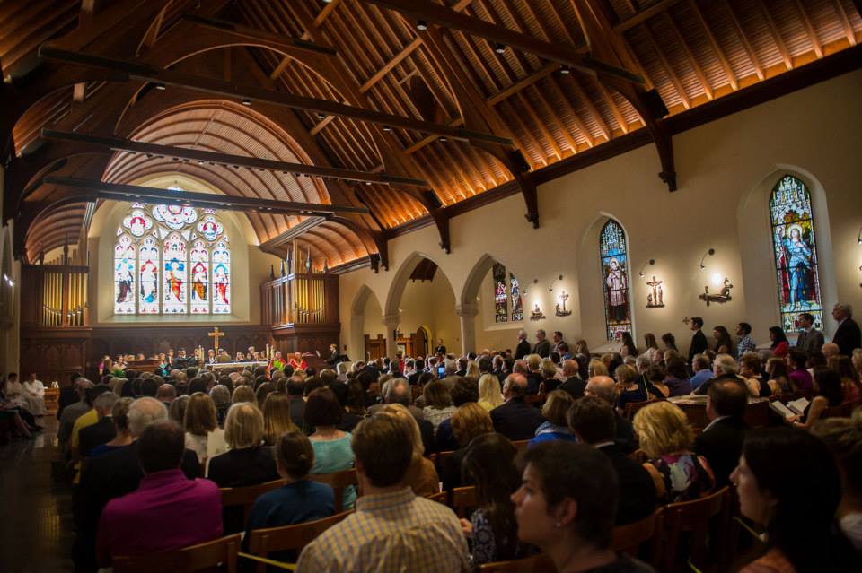 Georgetown community members gather in a chapel with stained glass windows.