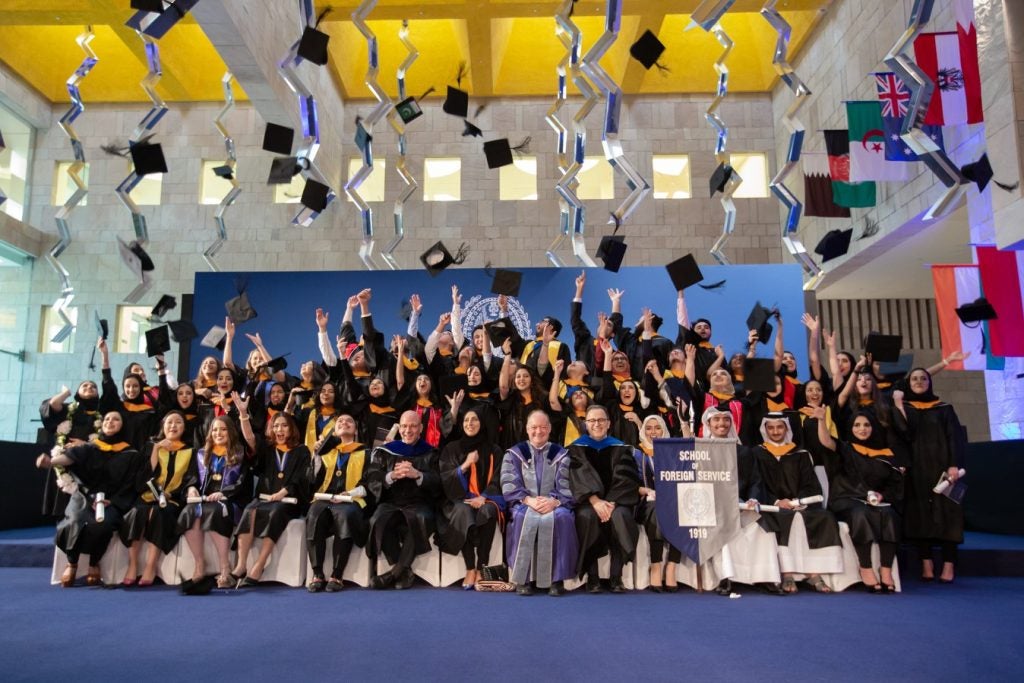 A class of students throw their graduation hats in the air at their commencement ceremony.