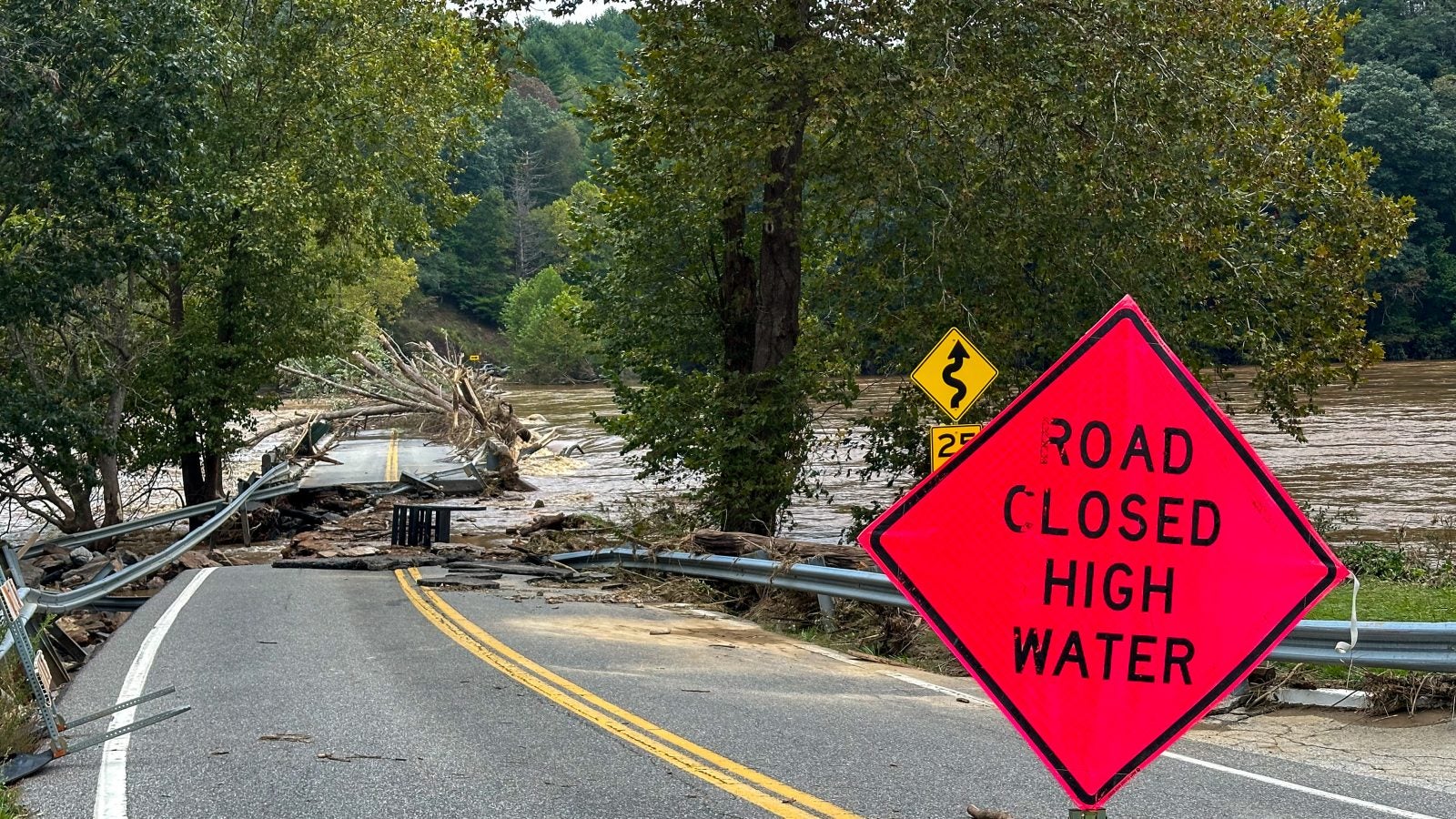 A road sign warns of road closure due to hurricane damage.