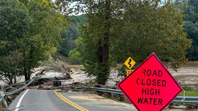 A road sign warns of road closure due to hurricane damage.