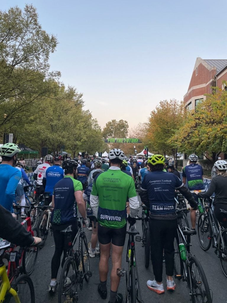 The backs of bikers at the starting line of a race.