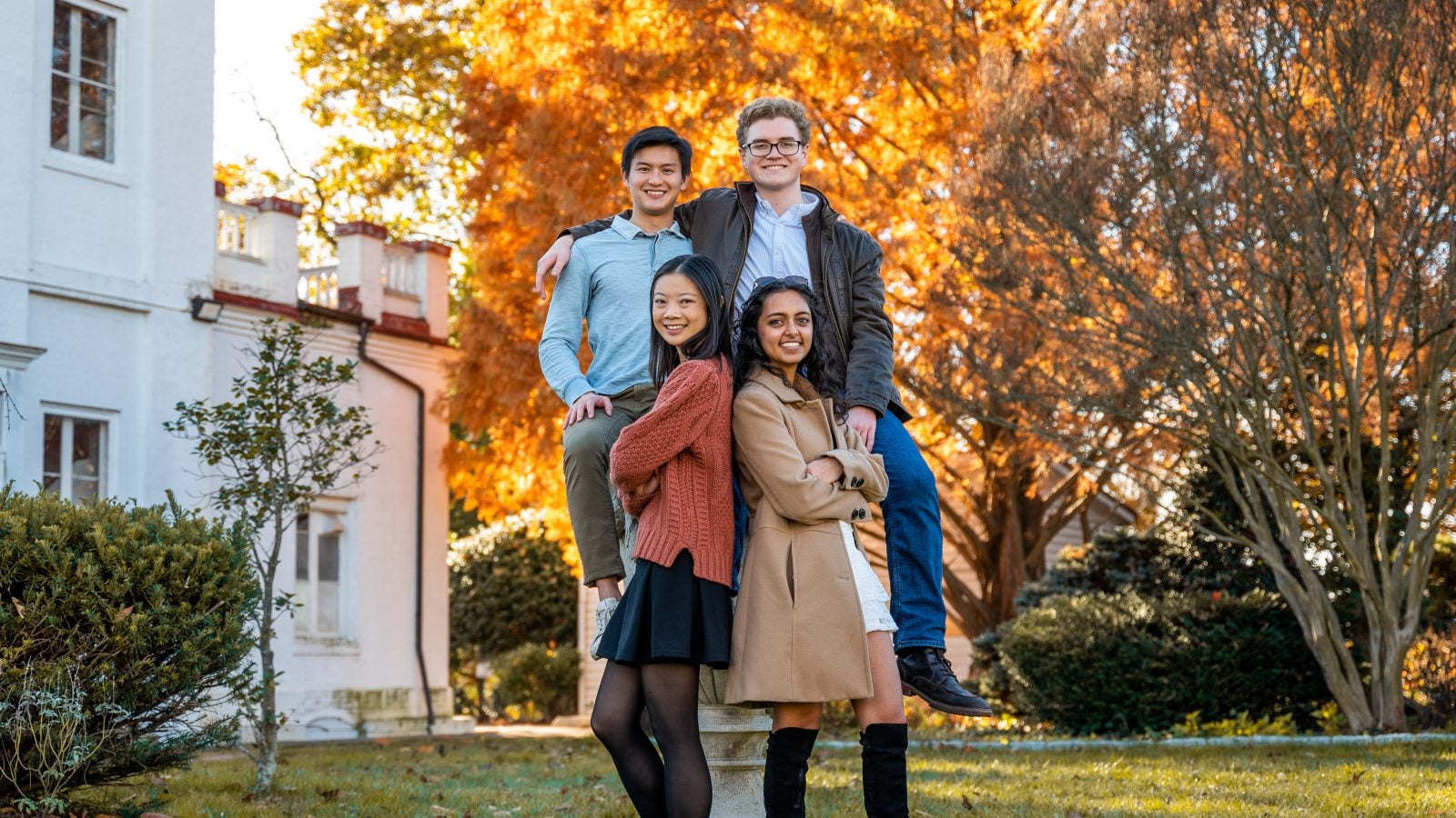 Four friends pose for a photo by the observatory on an autumn day