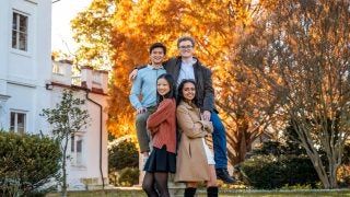 Four friends pose for a photo by the observatory on an autumn day