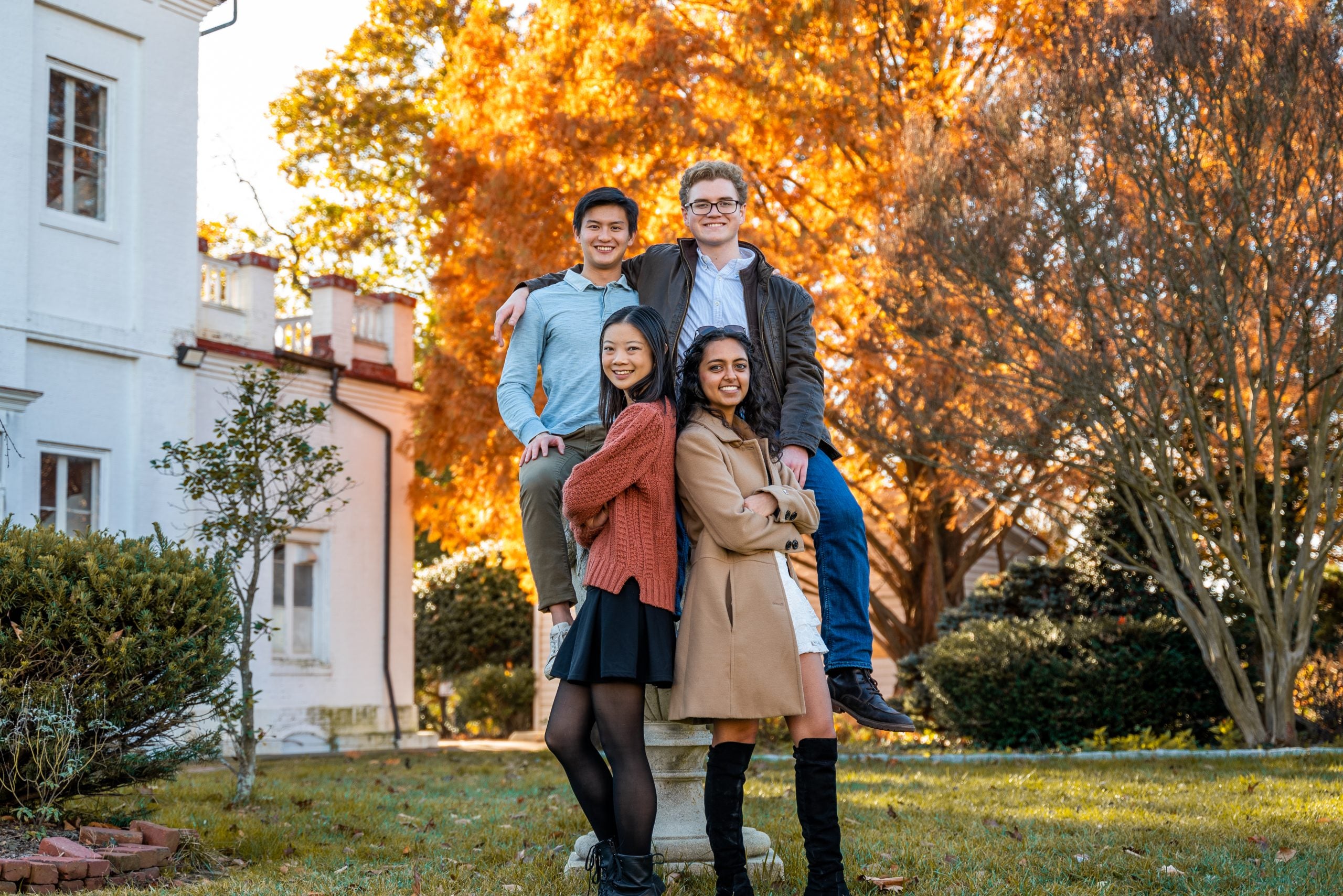 Four friends pose for a photo by the observatory on an autumn day