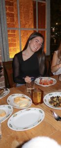 Young woman wearing black at a dinner table at night