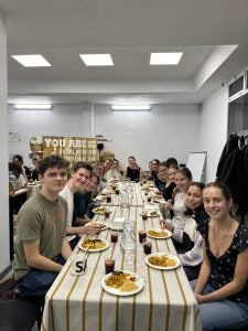 Students sitting at a long table for a meal