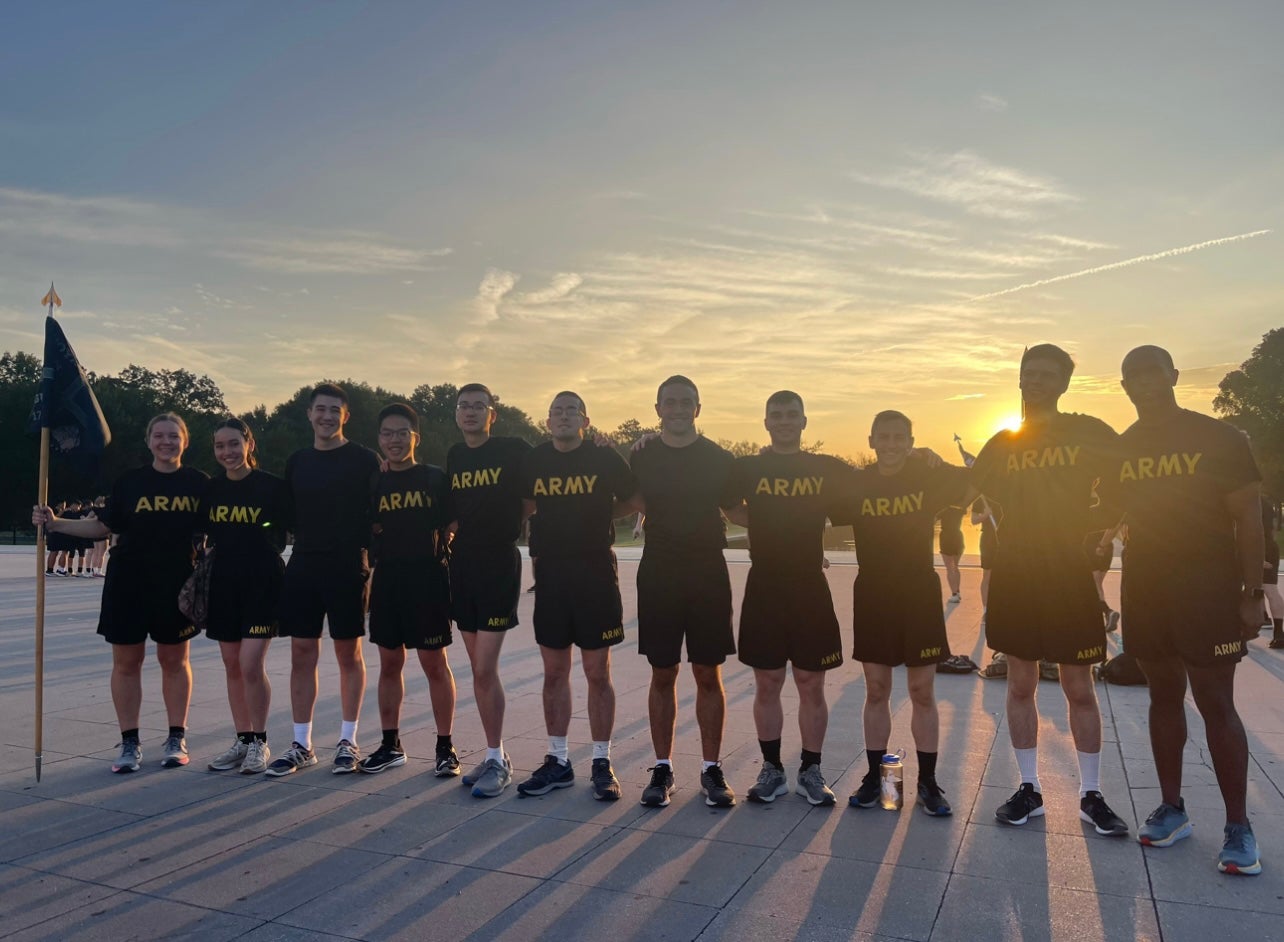 Army cadets in Army T shirts pose for a photo during sunrise at the National Mall