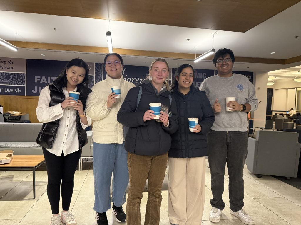 Four students holding cups of hot chocolate