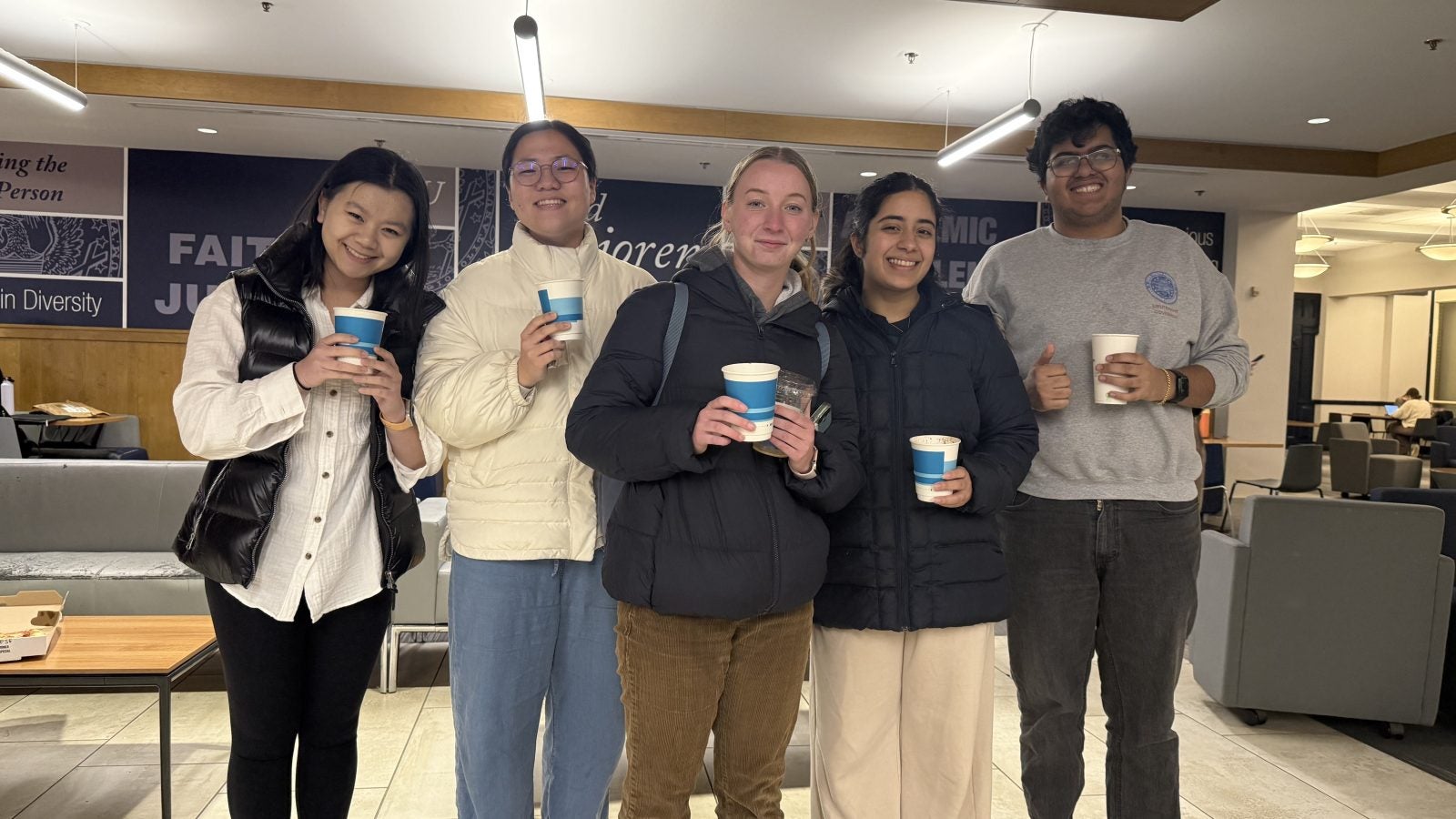 Four students holding cups of hot chocolate