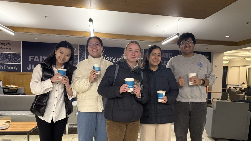 Four students holding cups of hot chocolate