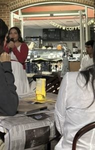 Young woman in red dress sings in a coffee shop