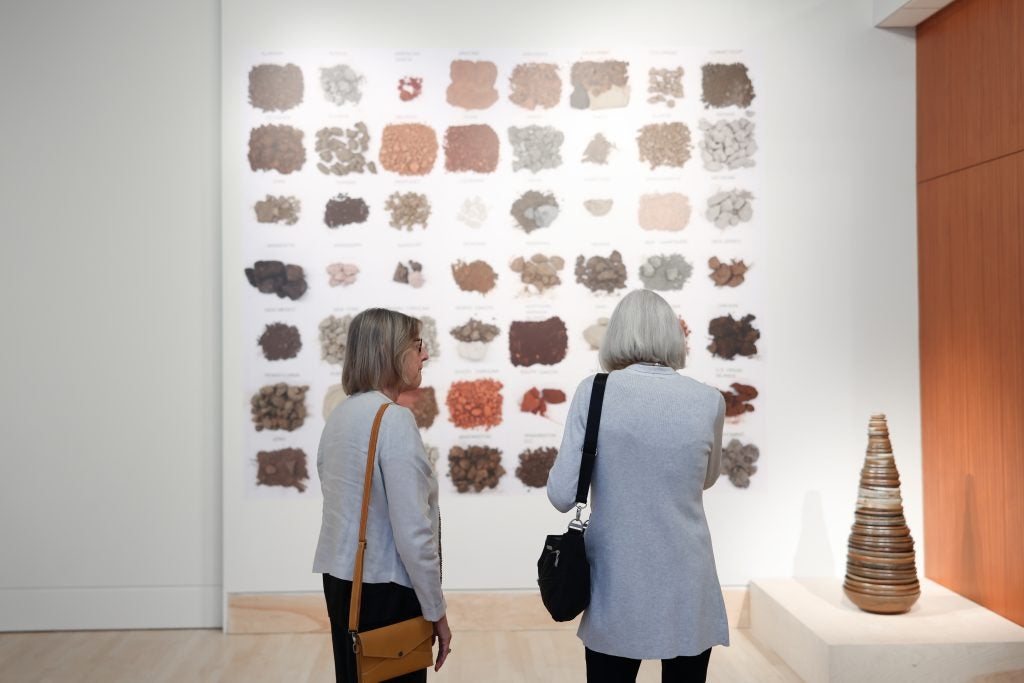 Two women look at artwork in a gallery.