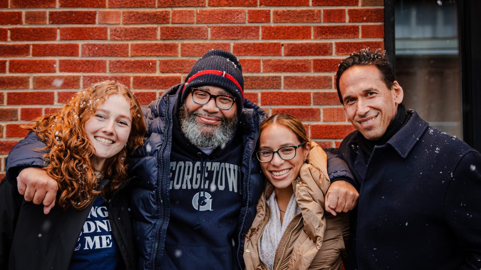 Two female student pose with a recent exoneree and their professor.