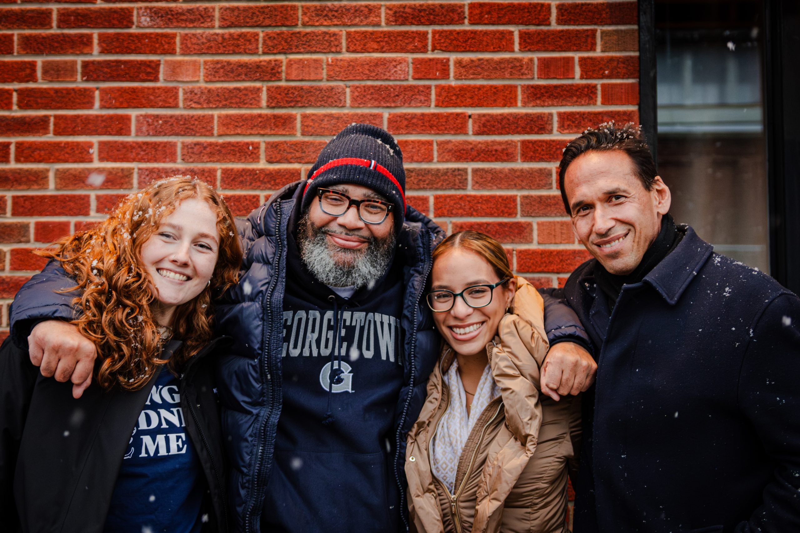 Two female student pose with a recent exoneree and their professor.