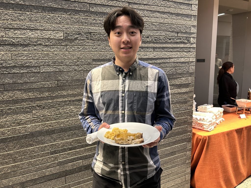 A young Asian man with a plate of food