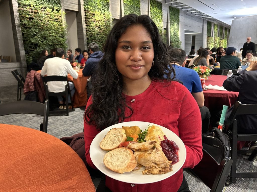 A young woman in a red sweater with a plate of food