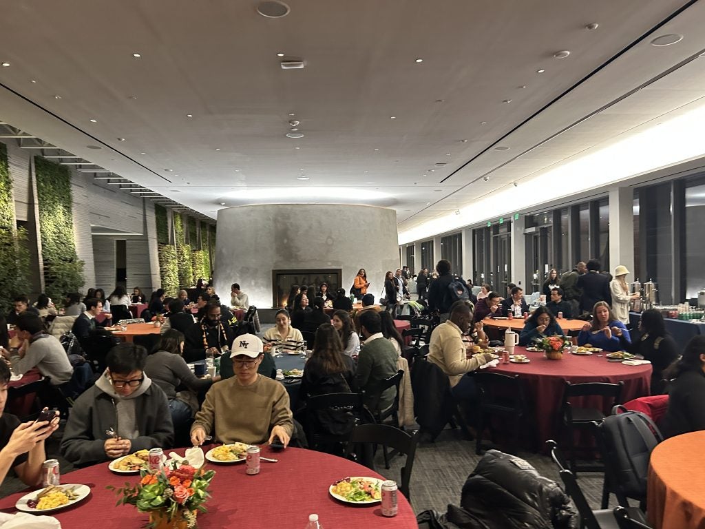 A room with people and tables for Thanksgiving