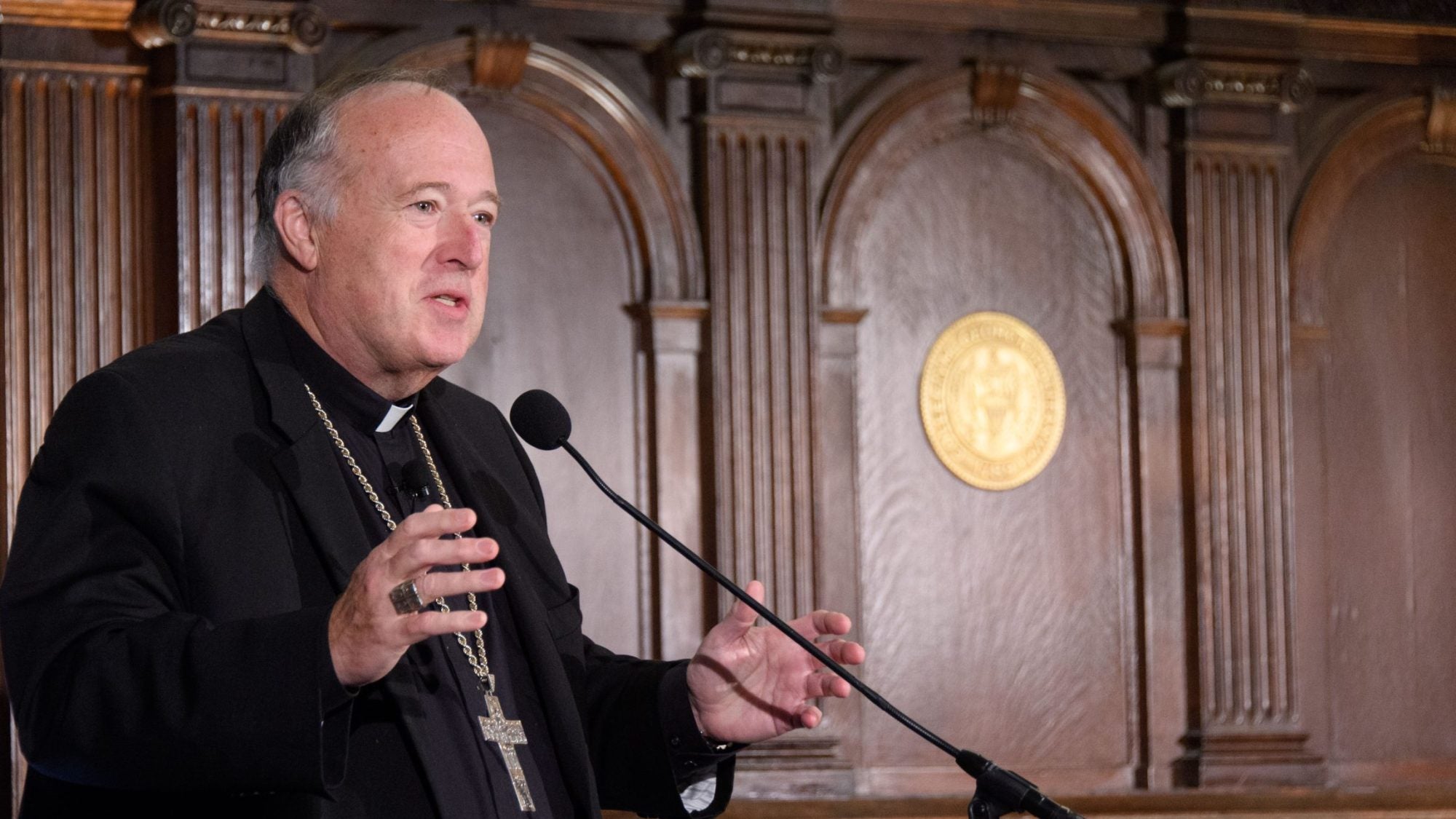 Cardinal Robert McElroy speaks from behind a podium at Georgetown.