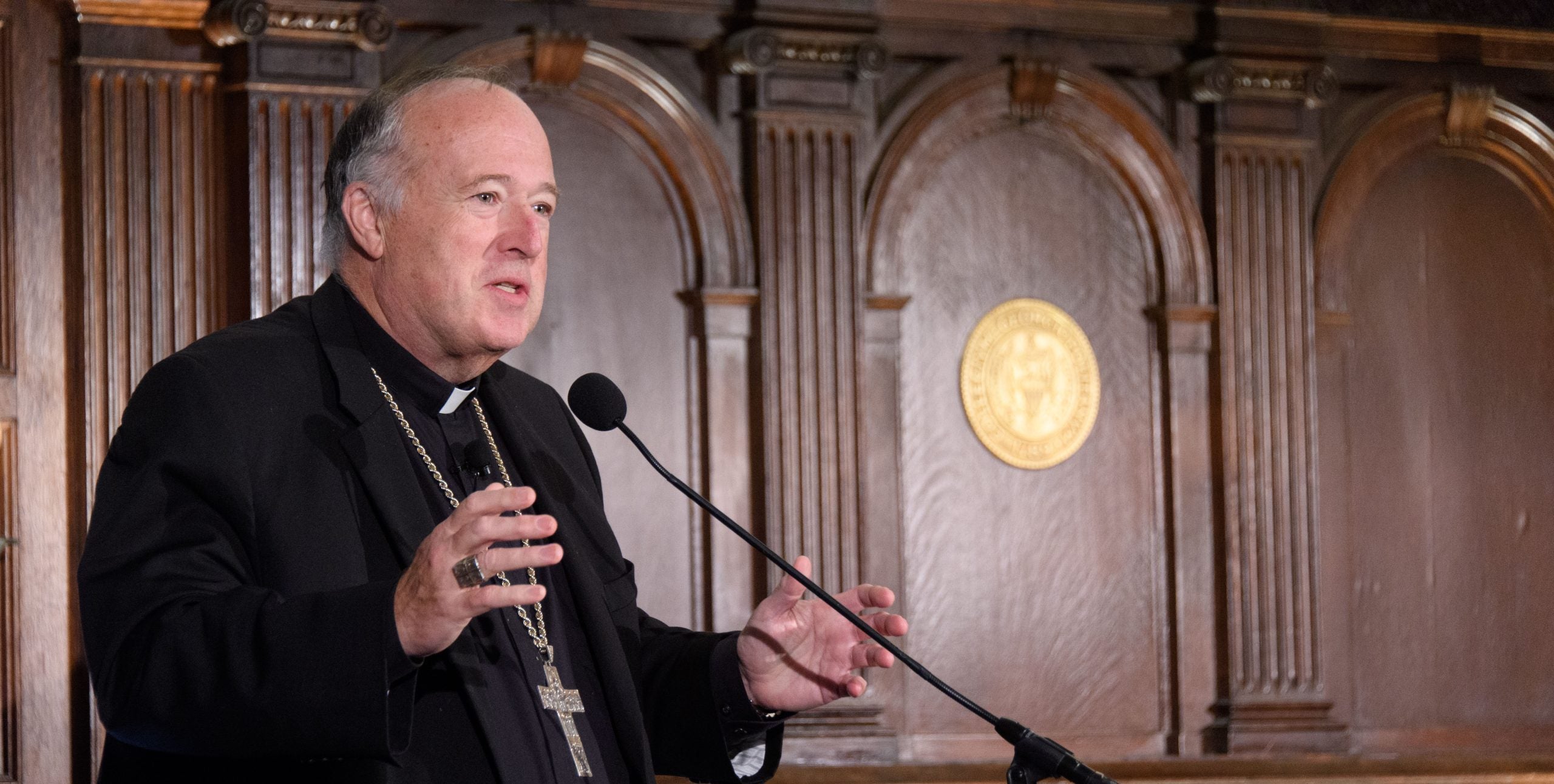 Cardinal Robert McElroy speaks from behind a podium at Georgetown.