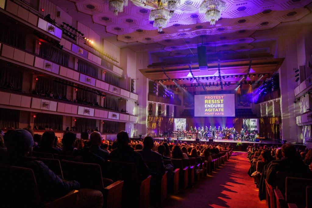 Audience members in the Kennedy Center watch a performance on the stage.