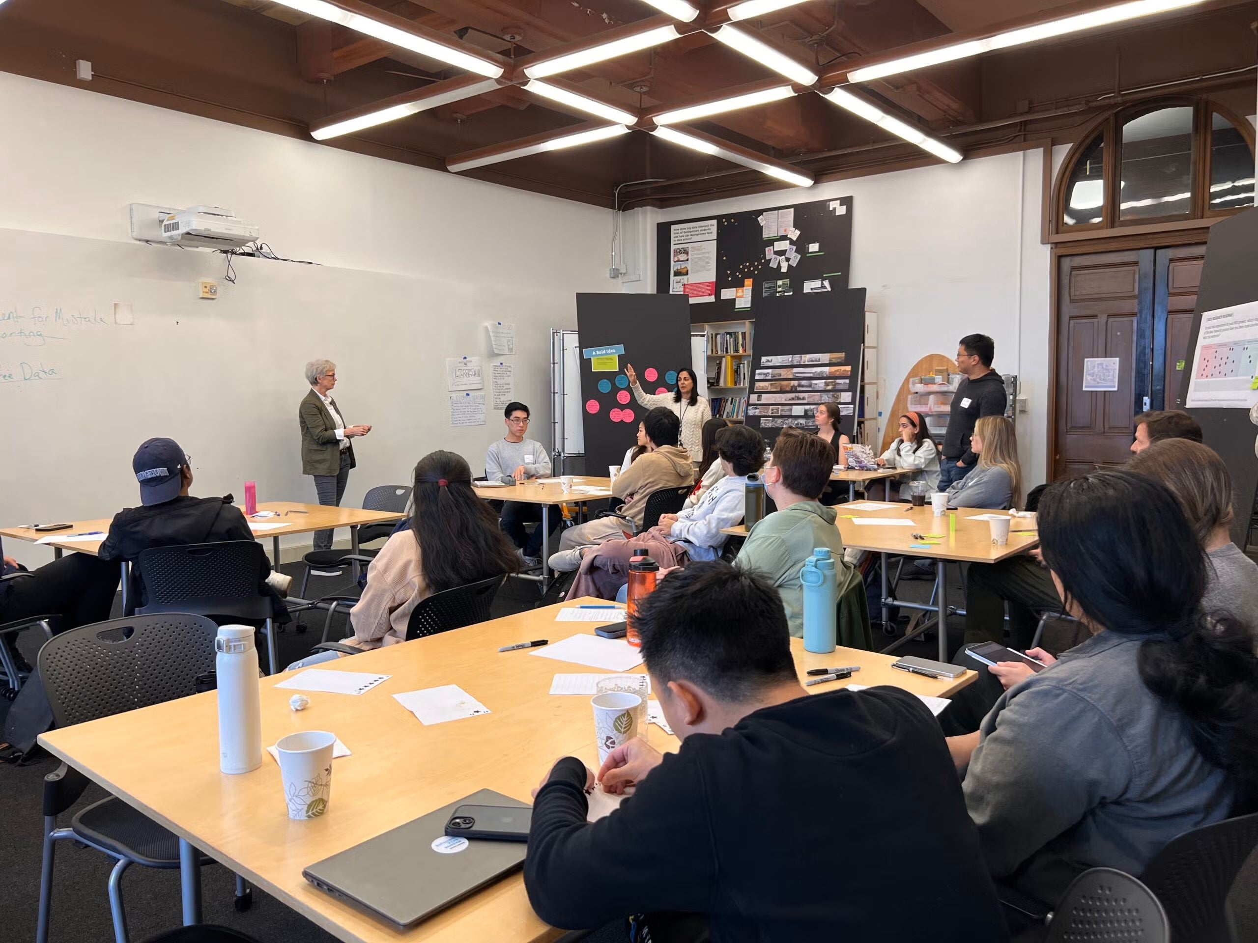 Two professors speak to students in a classroom