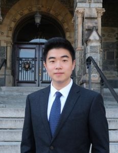 Harry Yang in a suit with a blue tie on Healy steps