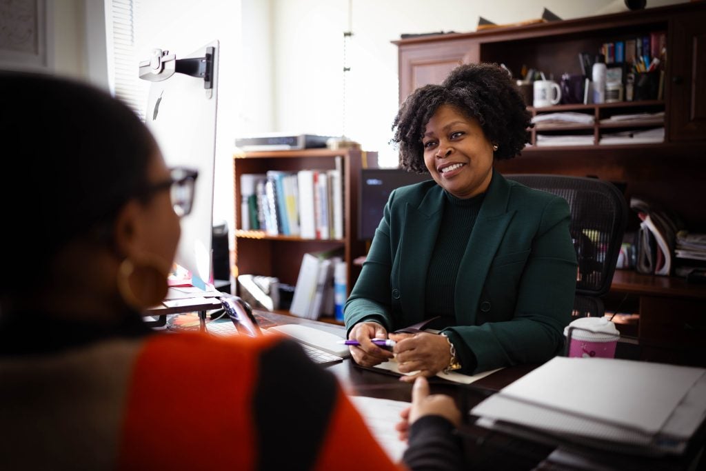 Paula Thompson, CEO and president of Voices for a Second Chance, smiles while in a meeting at her desk.