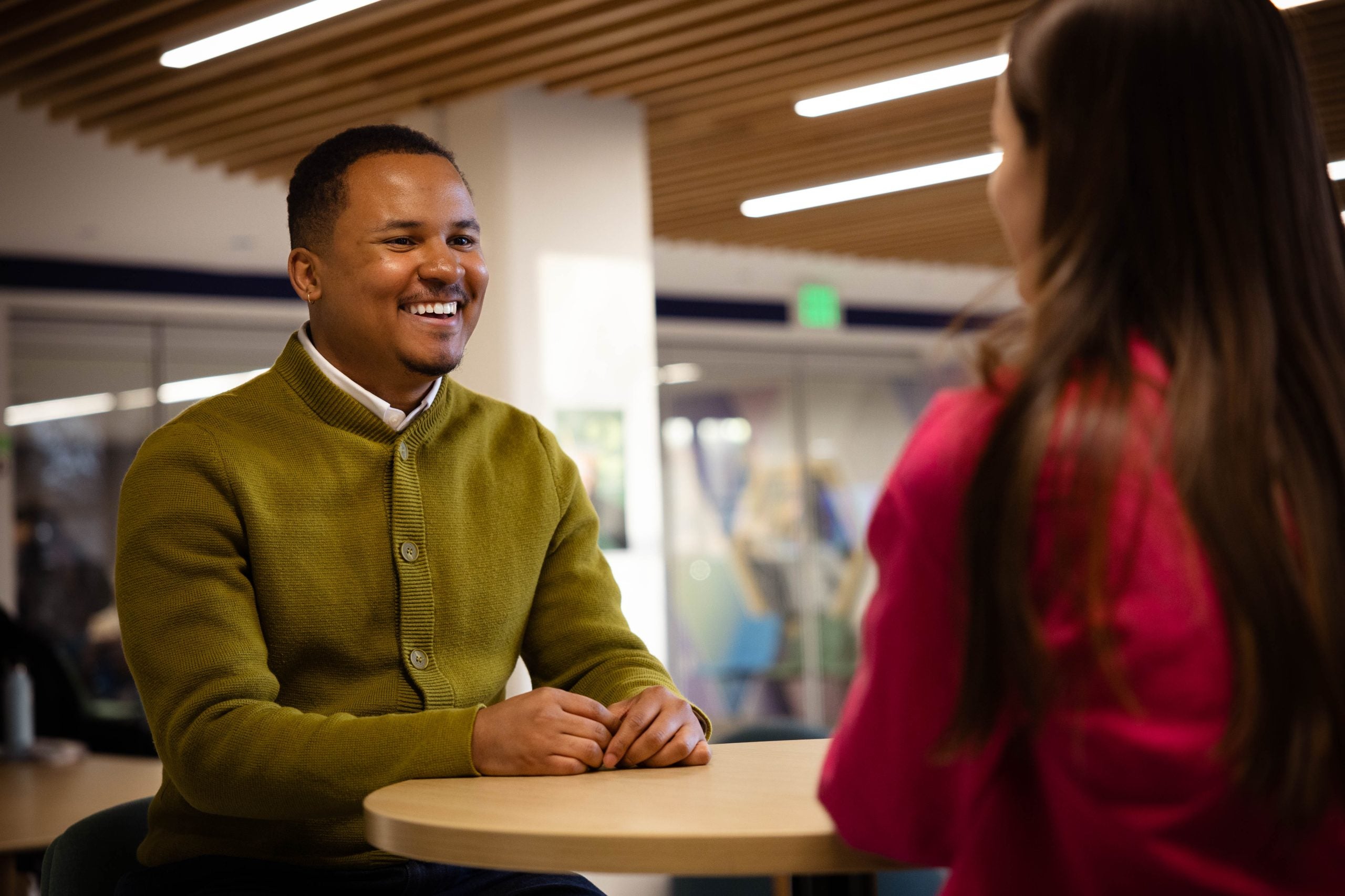 Lionell Daggs talks to a student while seated at a table