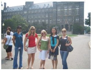 A group of female college students stand in front of a stone building on Georgetown's campus in the summer of 2007.