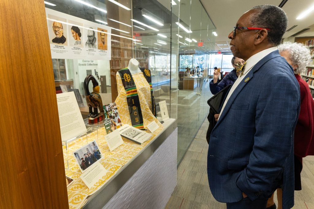 The president of Xavier University of Louisiana looks at an exhibit case in Georgetown's Library.