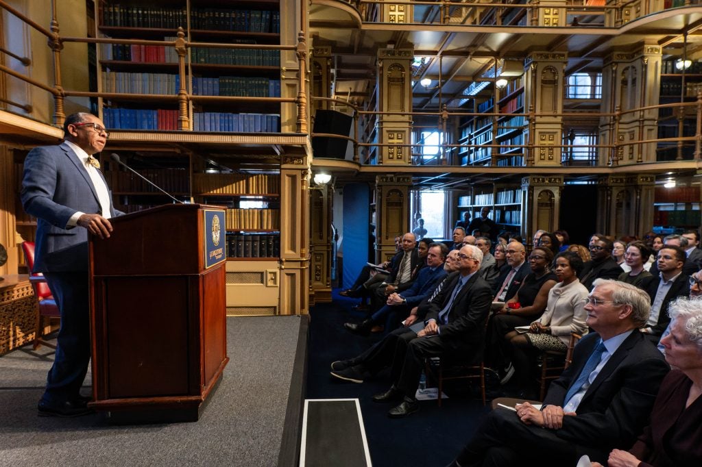 The president of Xavier University of Louisiana speaks from behind a podium to a crowd in Georgetown's Riggs Library.