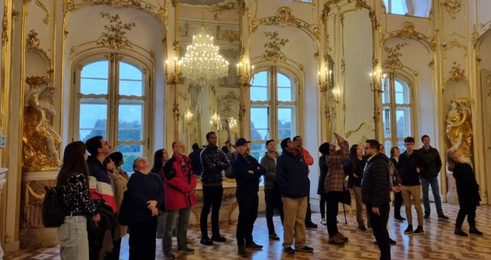 A group of people in an ornate room in a castle