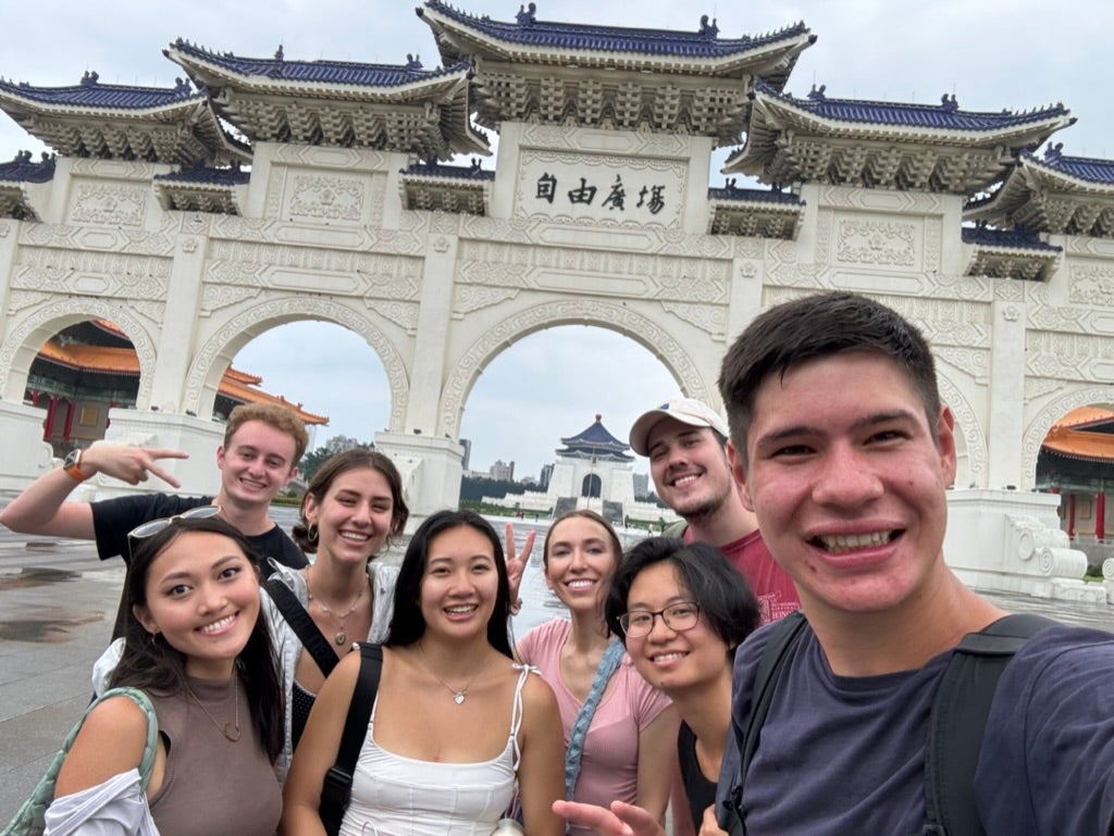 Goetz takes a selfie with several other young people in front of a landmark in China.