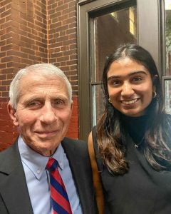 Dr. Fauci and a student pose together and smile.